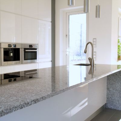 Eine helle Küche mit grauer Küchenabdeckung aus Granit